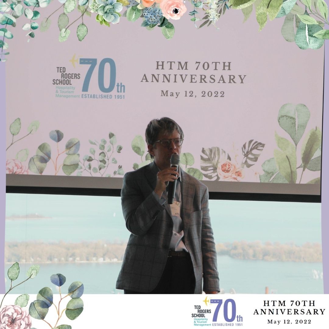 A woman is holding a microphone and speaking at HTM's 70th anniversary event.